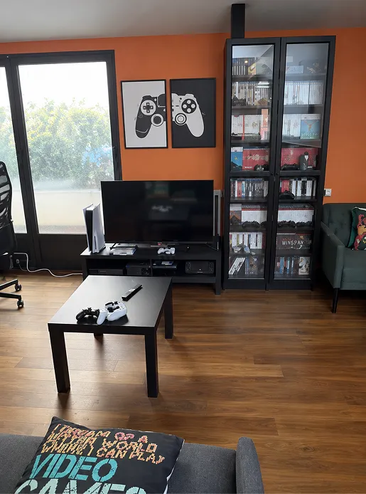 Le coin consoles du Repaire du Phoenix à Montauban : télévision, PlayStation 5, manettes et vitrine de jeux vidéo rétro